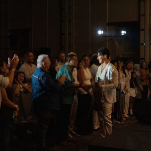 Smiling violinist greeting and shaking hands with guests after the performance